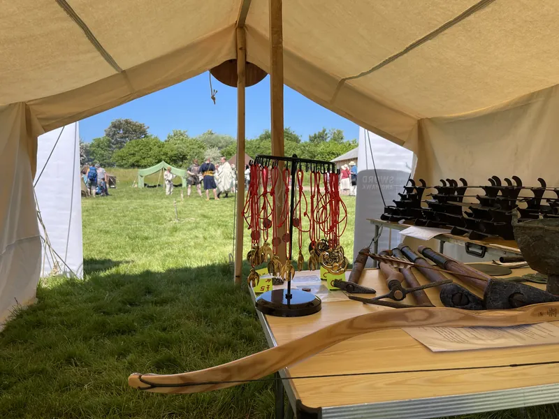 The Society's display under canvas: reconstructed blades laid in rows and pendants hanging on a stand