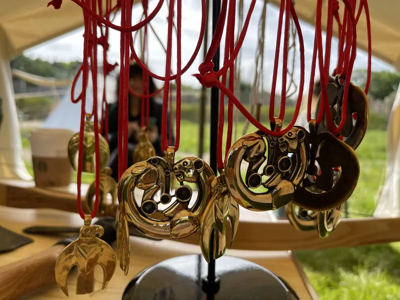 Gilded pendants in the animal style hanging on red cords above the display table