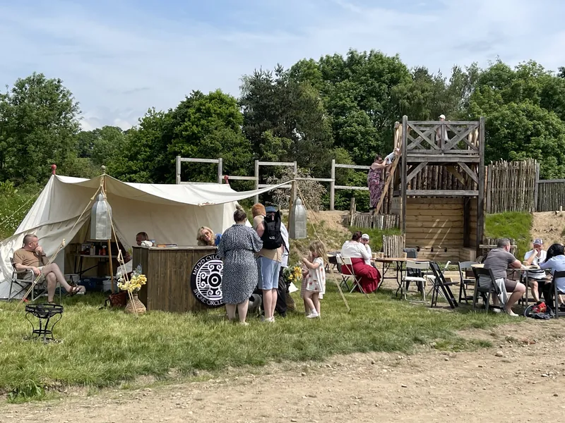 The encampment in use, with visitors seated outside the tents in the sun