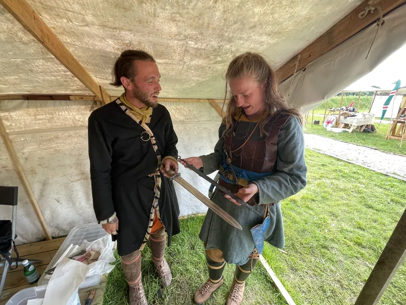 Two re-enactors examining a long sword together