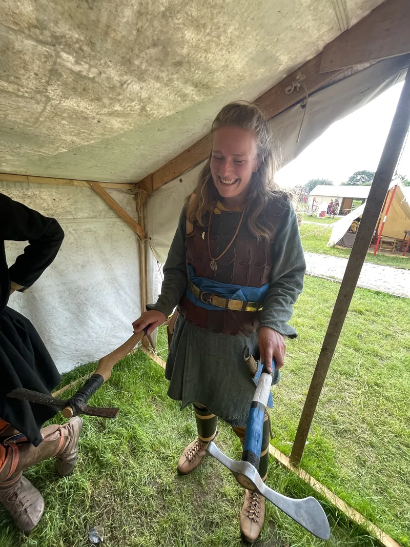 A young re-enactor holding a curved single-edged blade