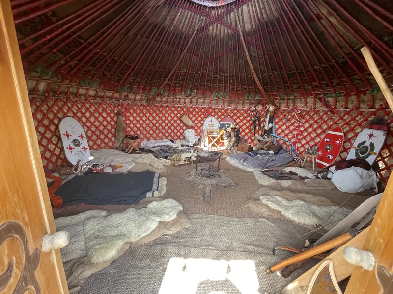 Inside the yurt: painted shields, felt hangings and furs arranged around the frame