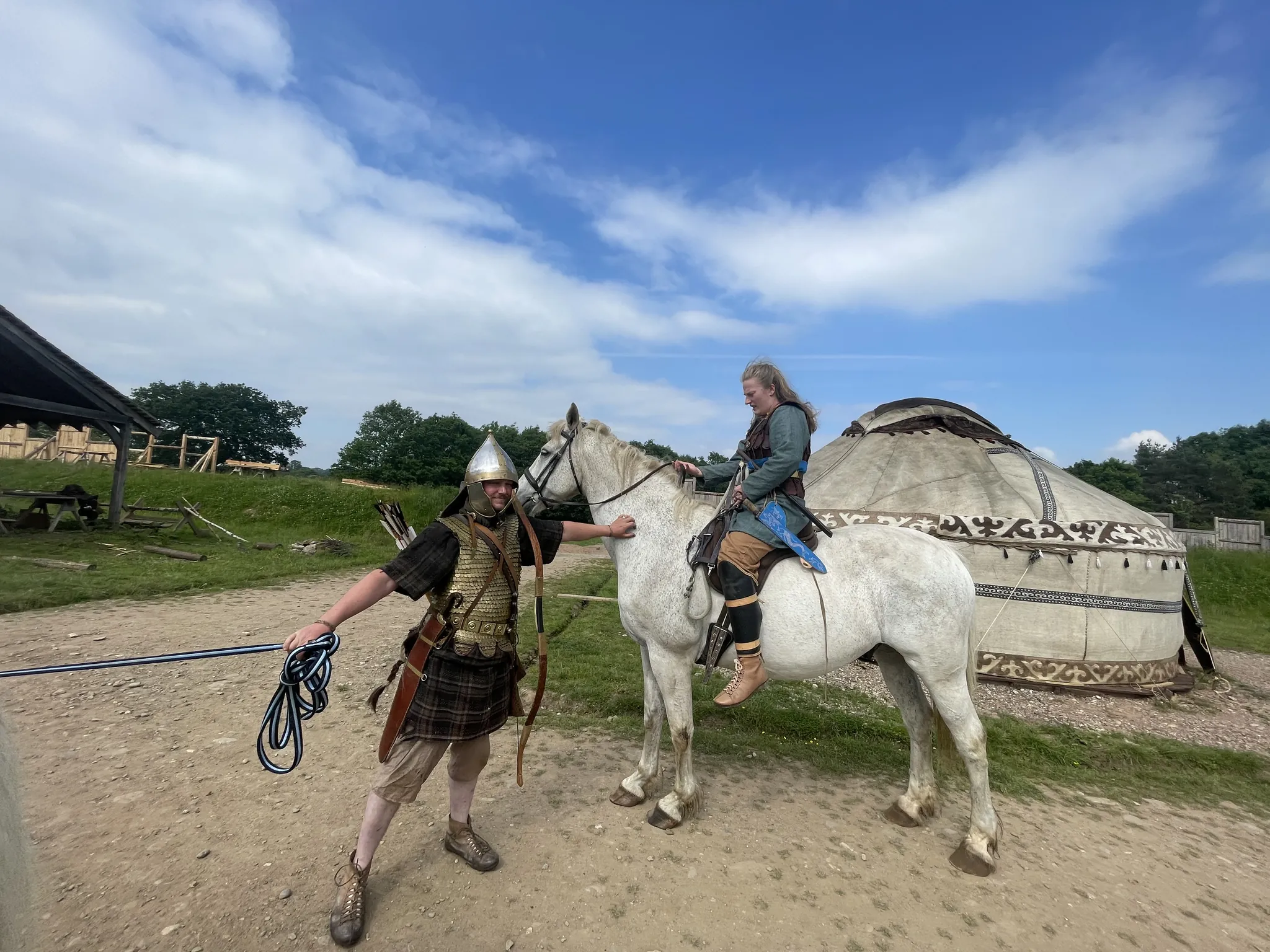 A mounted warrior in scale armour and helmet riding past the yurt