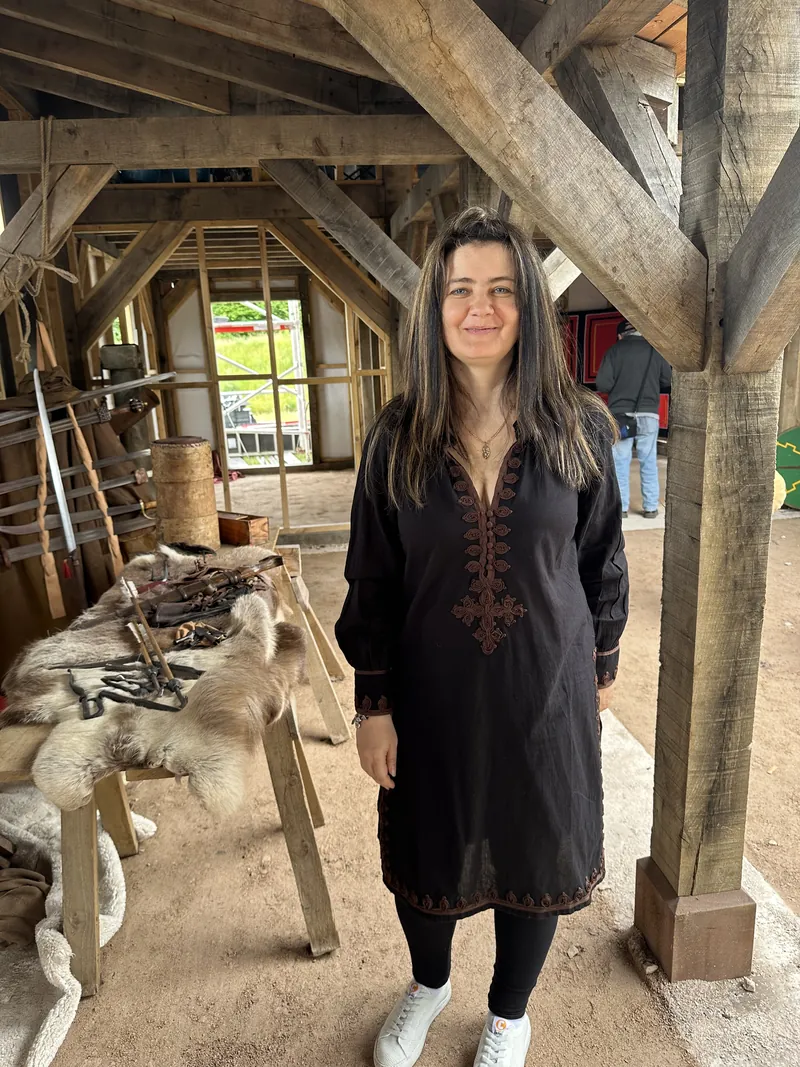 A Society member standing among the display tables in the fort's timber hall