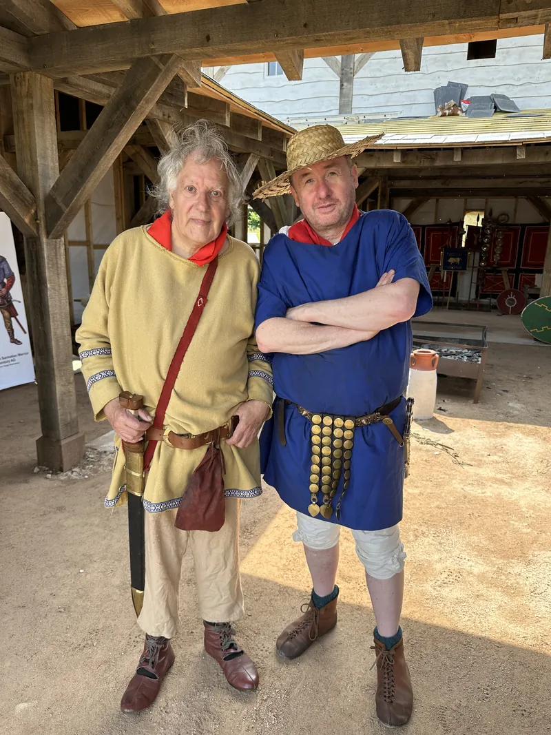Two men in reconstructed tunics photographed in the timber hall