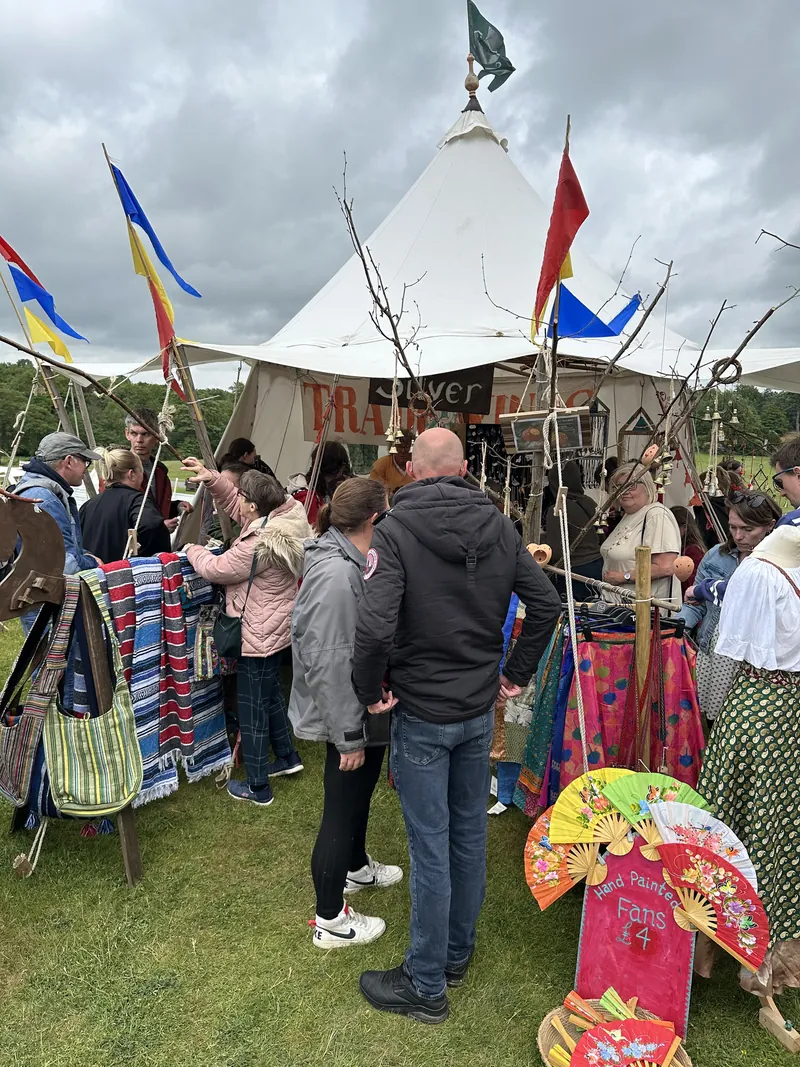 Visitors crowding the stalls outside beneath the flags