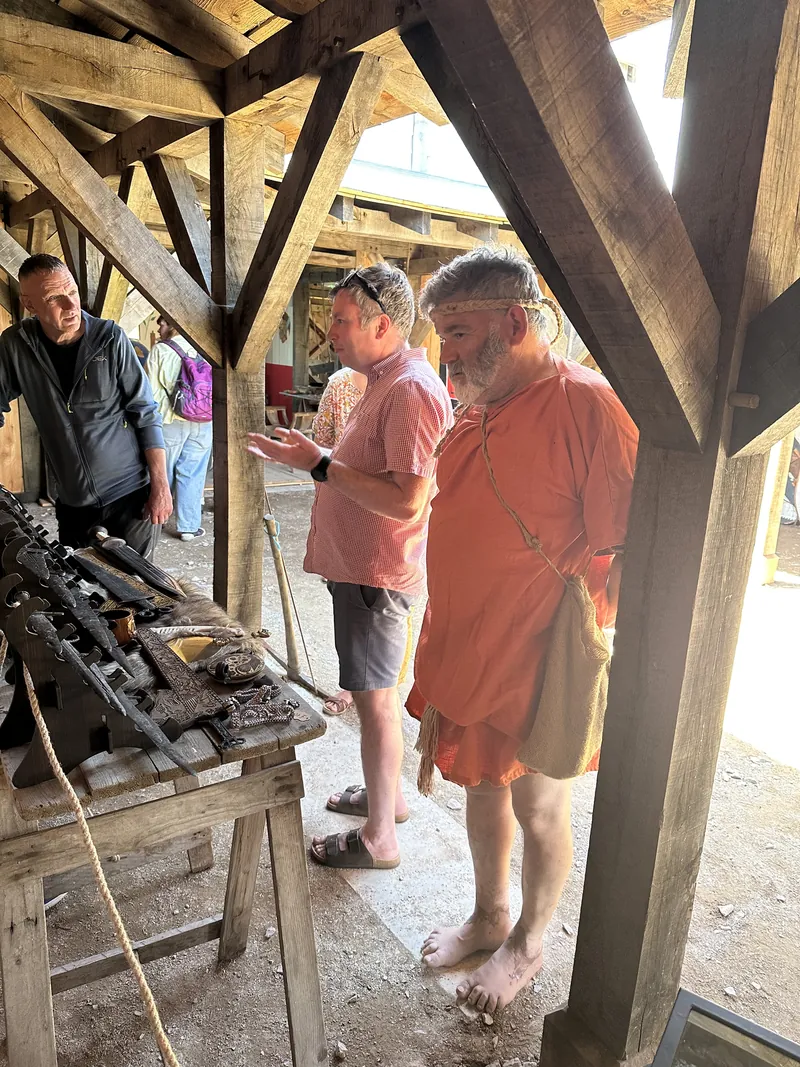 Visitors examining the row of blades laid along the trestle table