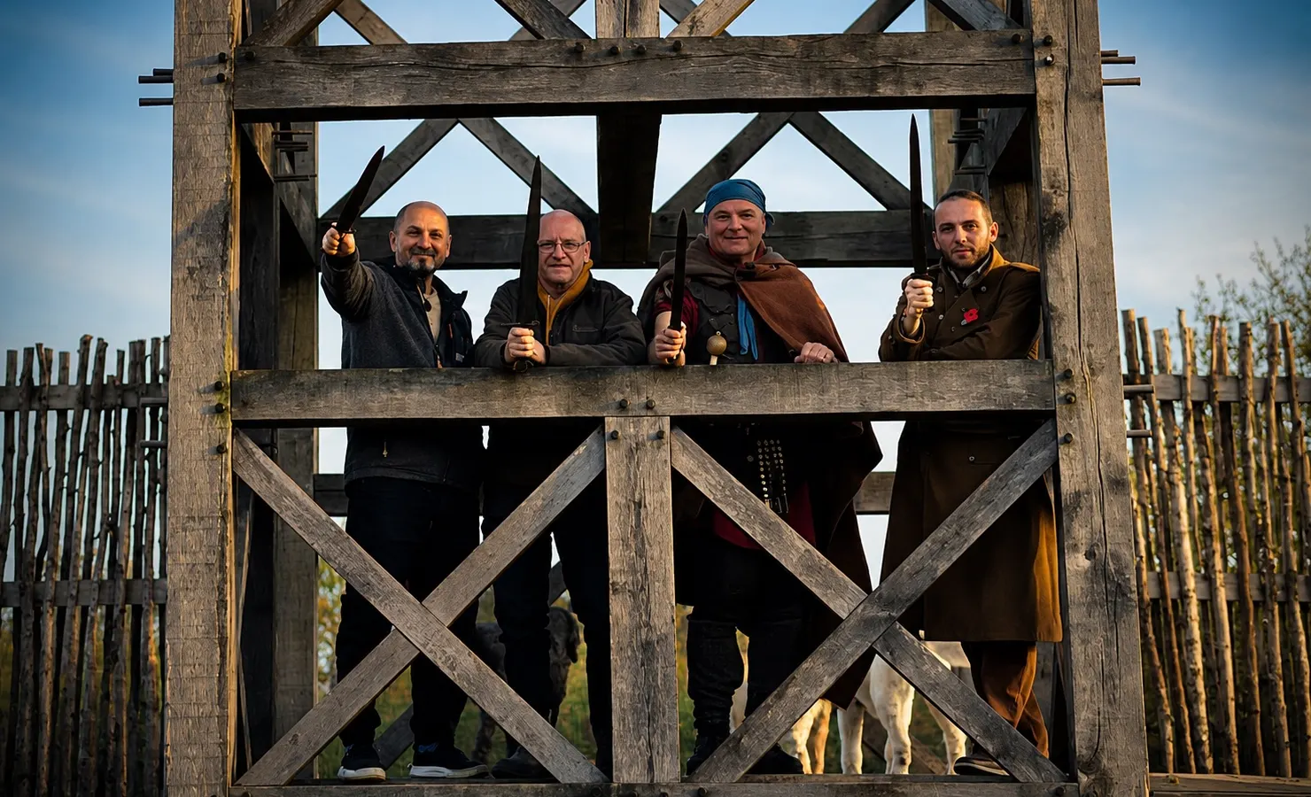 Four members of the Society on the timber gate tower at Park in the Past, holding reconstructed blades